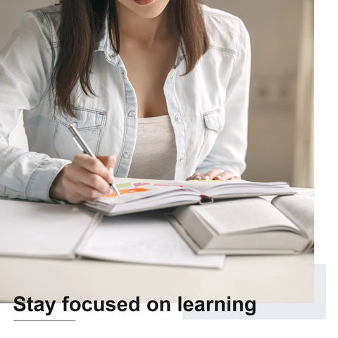 Person writing notes with colorful markers in a notebook, emphasizing focus on learning.