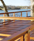 Wooden deck with Long Stud 1/8 Inch For HandiSwage Cable Infill Systems Pack Of 2, overlooking a body of water, trees in background.