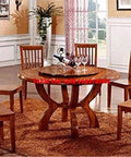 Wooden dining table set with round tabletop and six matching chairs, wine and glasses displayed, in a warmly lit dining room setting.