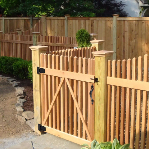 Outdoor wooden fence with installed Beefy Wood Gate Hardware Kit With 3-1/2 Inch T Hinges, heavy duty latch, decorative handle, black finish.