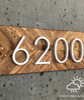 Wooden address plaque with number 6200 and indoor/outdoor applications icon.