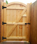 Wooden gate with Six Pack 2 Inch Black T Strap Shed Hinge Beefy Heavy Duty Barn Door Hinges installed, showcasing solid iron construction.