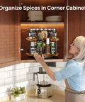 Woman using 12 Inch D Shaped Lazy Susan Spice Rack Organizer, Height Adjustable Two Tier Rotating Turntable in kitchen cabinet.