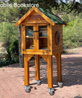 Wooden mobile bookstore on four 2 inch side mount caster wheels for outdoor use, books visible behind glass doors.