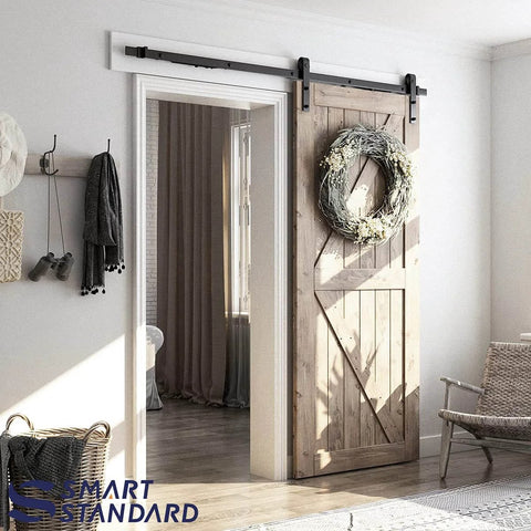 6.6 FT Sliding Barn Door Soft Close Hardware Kit installed on a wooden door with wreath, showcasing J Shape design, smoothly and quietly.