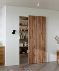 36" Concealed Sliding Barn Door Hardware Kit with Soft Close Mechanism for 28in Passage Opening, hidden sliding door displayed in kitchen.