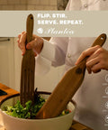 Person using Spurtle Kitchen Tools Wooden Set for Nonstick Cookware, stirring salad with wooden spurtles, in kitchen setting