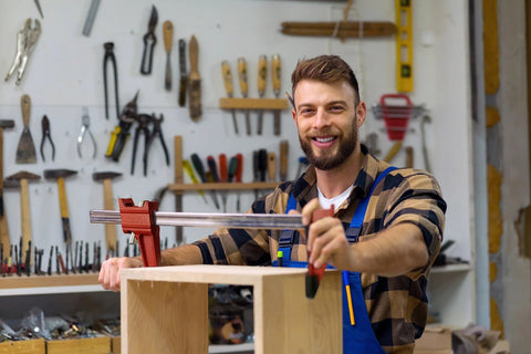 Woodworker using 12 inch woodworking bar clamps set in workshop