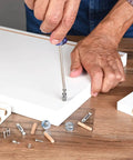 Man assembling furniture using Assorted 21 Piece Wooden Dowels Set M6 M8 M10 Hardwood Grooved Fluted Pins For Woodworking And Furniture DIY Carpentry Projects, Easy Glue Bond, Strong Joints, Ideal For Screw Holes And Repairs.