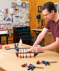 Man using 6 inch woodworking bar clamps for assembly in a workshop