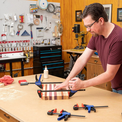 Man using 6 inch woodworking bar clamps for assembly in a workshop
