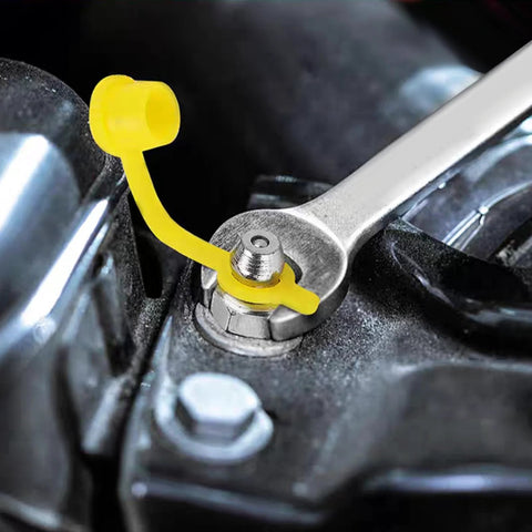 Close-up of 315 Piece SAE And Metric Grease Fittings Assortment Kit with Zerk fitting in use on machinery with yellow cap and wrench.