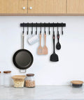 Wrought Iron Kitchen Holder: 10-Hook Wall-Mounted Utensil Rack with Black Finish holding pan, mug, and utensils