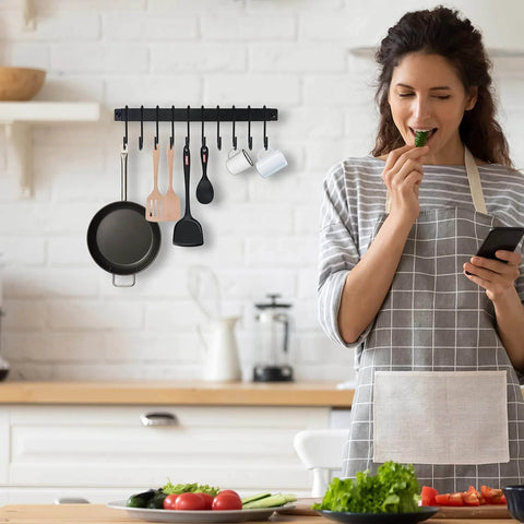 Wrought Iron Kitchen Holder: 10-Hook Wall-Mounted Utensil Rack with Black Finish displayed in kitchen with woman preparing food