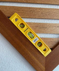 9 Inch Speedlite Torpedo Level Yellow Built With High Impact Composite For Tough Jobsite Use Non Conductive Design Makes It A Handy Third Hand For Electricians And Pro DIYers Swanson Tool TL011 on wood surface