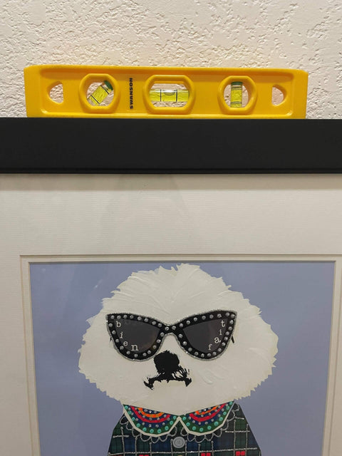 9 Inch Speedlite Torpedo Level Yellow Built With High Impact Composite For Tough Jobsite Use Non Conductive Design Makes It A Handy Third Hand For Electricians And Pro DIYers Swanson Tool TL011 placed on a picture frame