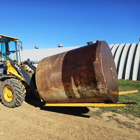 Forklift with 84 Inch Fork Extensions For Forklifts, Heavy Duty Pallet Fork Extensions 4.5 Inch Wide, lifting a large metal cylinder outdoors