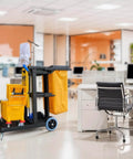Beefed-Up Heavy Duty Commercial Cleaning Cart With 3 Shelves And Lid, Waste Bag Included in an office setting.