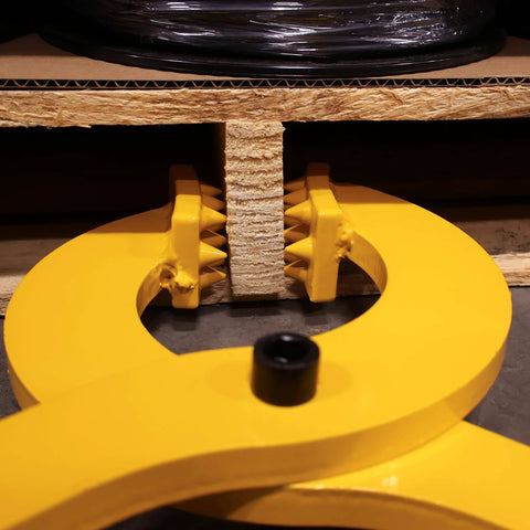 Front view of a yellow Beefy Heavy Duty Pallet Puller Clamp With 6000 Lb Capacity gripping a wooden pallet, showing its sturdy steel jaws.