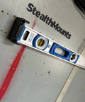 Universal level holder 2 pack securely holds level on a wall in a workshop.