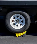 Trailer wheel supported by Curved Camper Leveler and Wheel Chock for RVs and trailers up to 30,000 lbs by Camco.