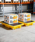 Spill Containment Pallet Set For Two Drums With Drain Outlet in warehouse holding boxes, heavy duty plastic platform, 2000 lbs capacity.