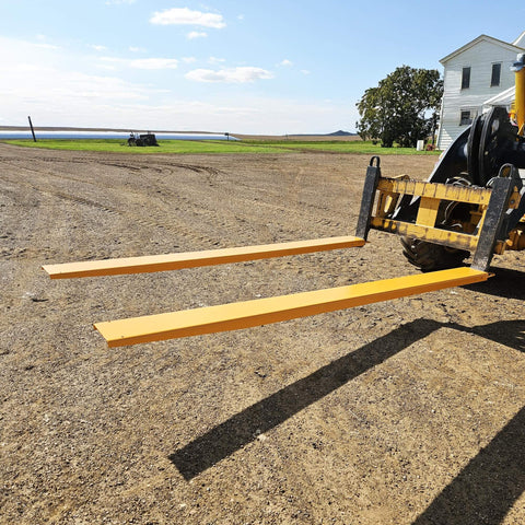 Installed 84 Inch Fork Extensions For Forklifts, Heavy Duty Pallet Fork Extensions 4.5 Inch Wide, Yellow YINTATECH on dirt field