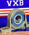 20mm Bore Miniature Stainless Steel Pillow Block Mounted Bearing on a colorful background.